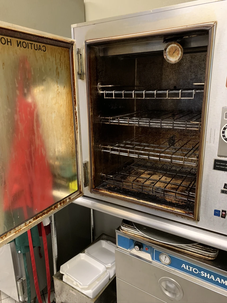 First oven-interior view, with dark deposits on the door and inside surfaces